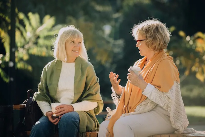 The Gardens of Buda | Senior friends talking outside and drinking coffee